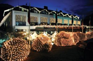 immagini di luci natalizie su edificio e piante