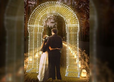 immagine con arco luminoso e una coppia di sposi